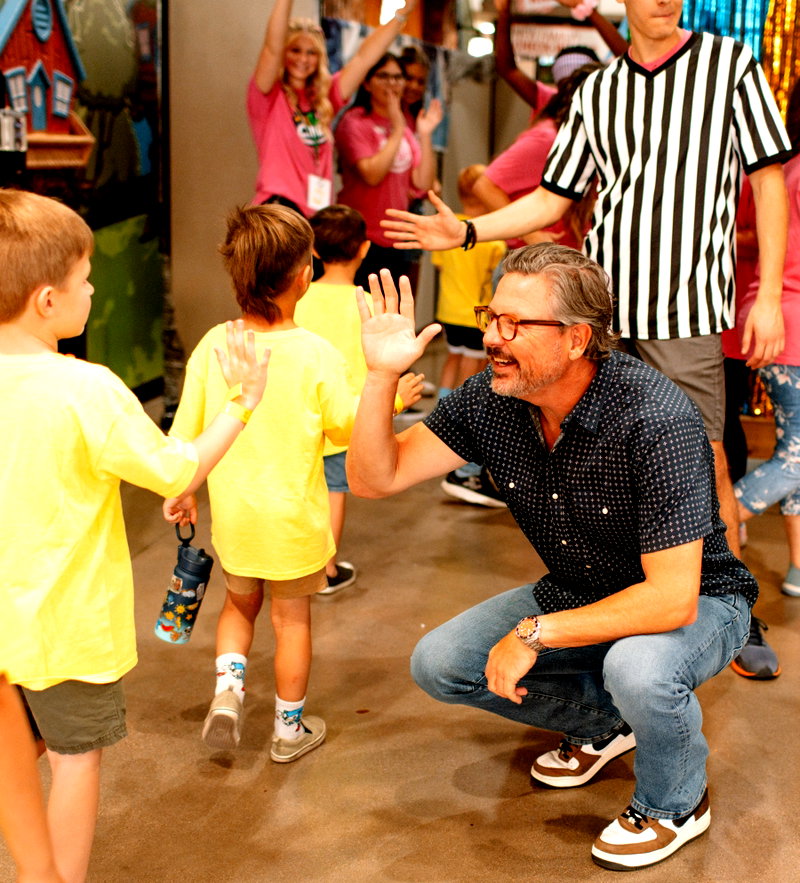 Pastor Chad giving high fives to kids at Sun Valley Community Church
